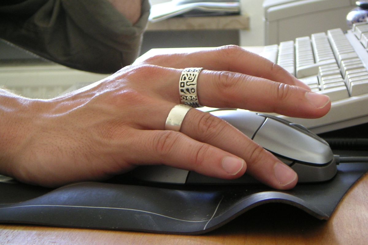 Ảnh minh họa: Male hand with two rings operating computer mouse.jpg